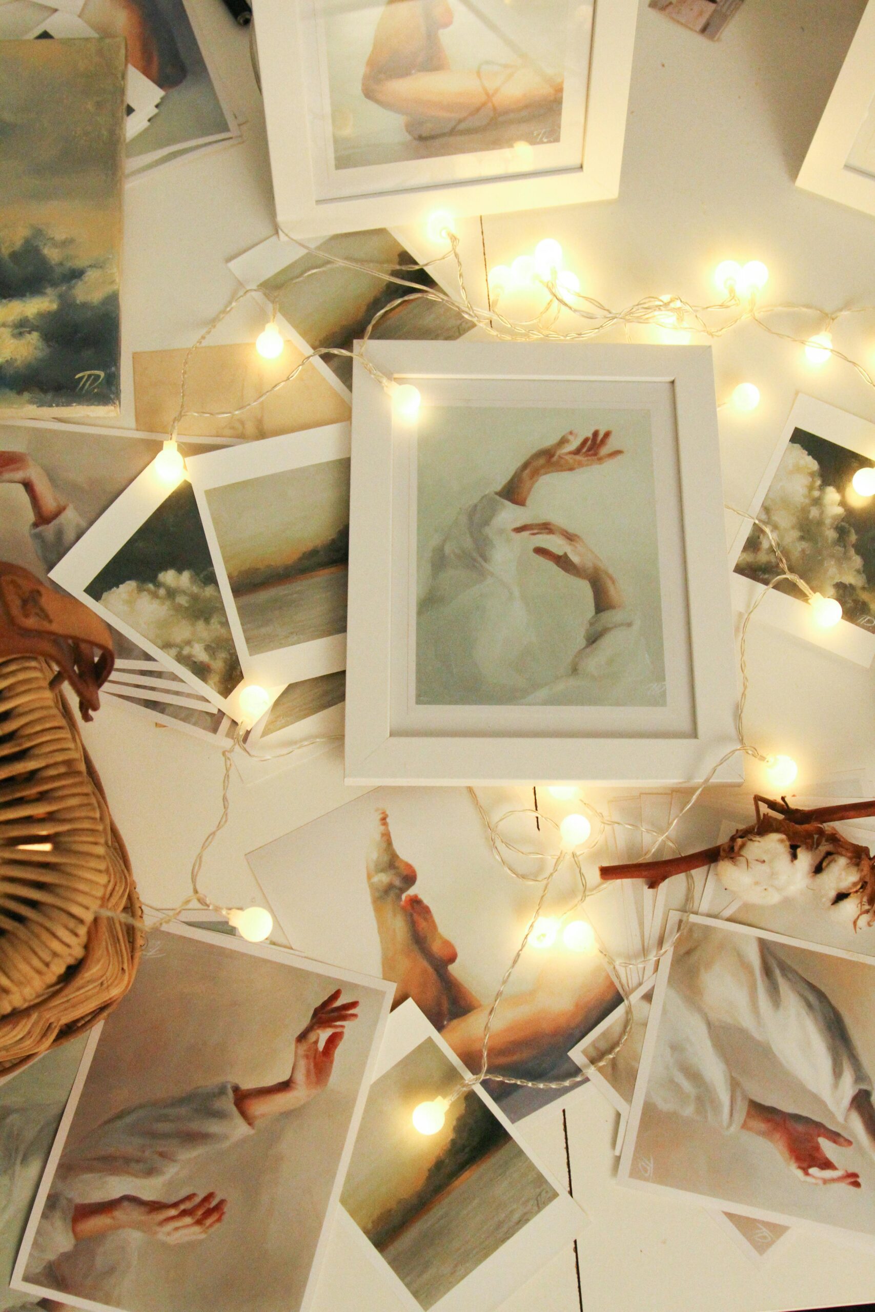 A collection of artistic photo prints surrounded by glowing string lights for a warm ambiance.