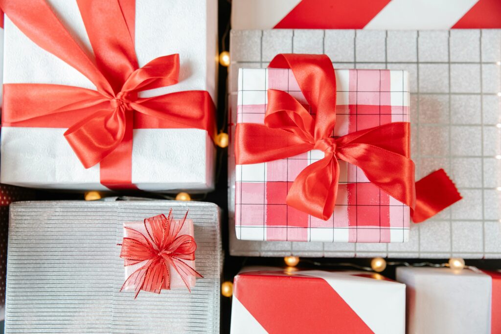 Top view of beautifully wrapped gift boxes with red ribbons, perfect for festive celebrations and special occasions.